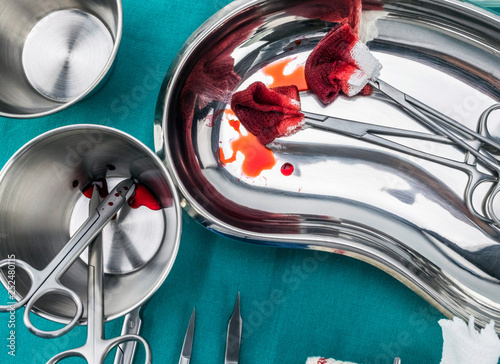 Scissors surgical with torundas soaked with blood on a tray metal in an operating theater, composition horizontal, conceptual image photo