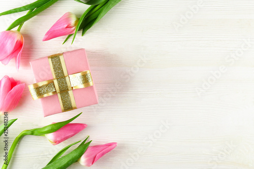 Fototapeta Naklejka Na Ścianę i Meble -  Fresh flower composition, bouquet of bi color pink tulips, white wooden texture table background. International Women's day, mother's day greeting concept. Copy space, close up, top view, flat lay.
