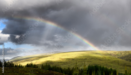 Double rainbow and dark clouds on An Liathanach mountain at Loch a Chroisg near Badavanich Scottish Highlands Scotland UK