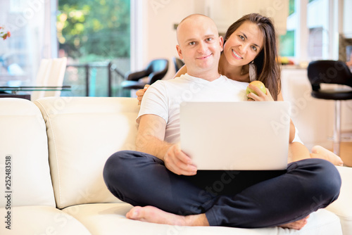 Young couple relaxing on sofa with laptop.Love,happiness,people and fun concept. © izikmd