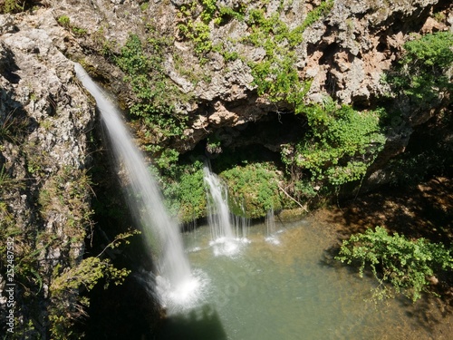 Fototapeta Naklejka Na Ścianę i Meble -  Wide shot of the 77-foot waterfalls at the Natural Falls State Park, West Siloam Springs, Oklahoma taken from the view deck.