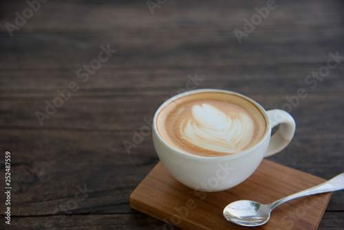 a cup of coffee on wood table, latte art