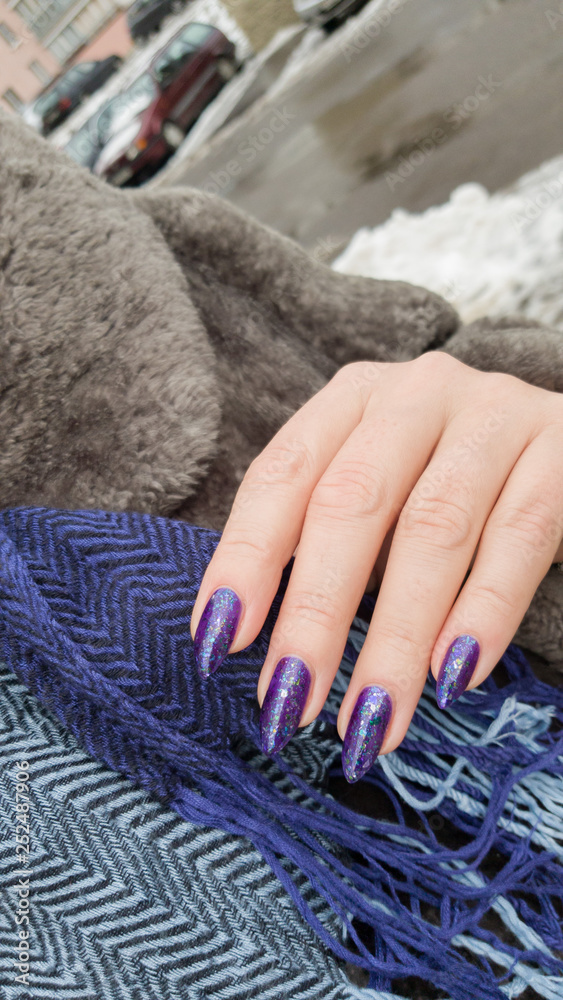 Fototapeta Female hands with long nails with purple nail polish