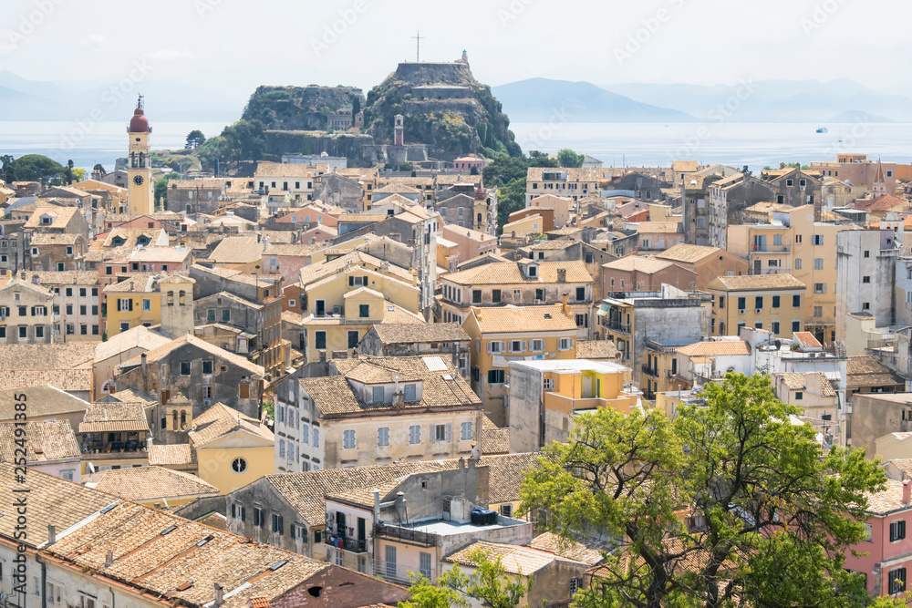 View on Corfu city or Kerkyra from New Fortress. Skyline of typical houses of old town. Tourist attraction and popular vacation destination. Sunny day in beginning of June. 