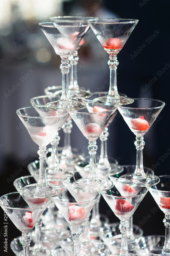 Champagne slide. Pyramid or fountain made of champagne glasses with cherry and steam from dry ice Champagne slide. Pyramid or fountain made of champagne glasses with cherry and steam from dry ice