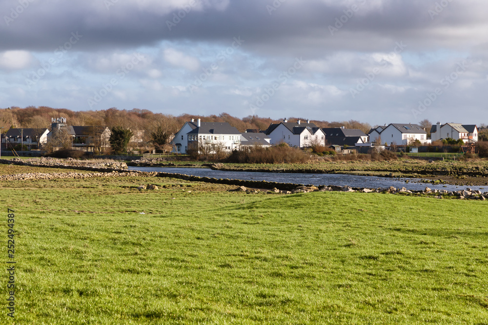 Houses, river and farm field in Clarinbridge