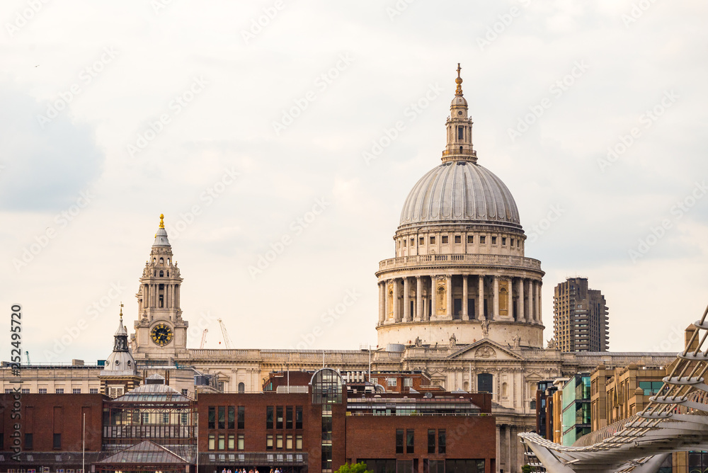 St Paul's Cathedral, Millennium footbridge and apartments near Thames river in London, United Kingdom. Travel concept. Summer holidays in London.