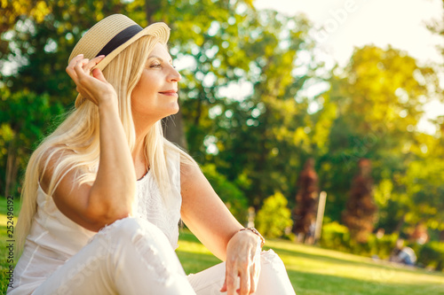 Happy mature woman at the park in summer