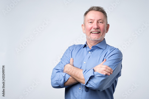Confident handsome mature man in casual suit looking at camera and smiling