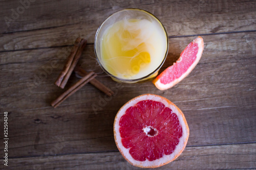 Orange juice with grapefruit. A glass of grapefruit juice on a wooden background. Cinnamon Cocktail