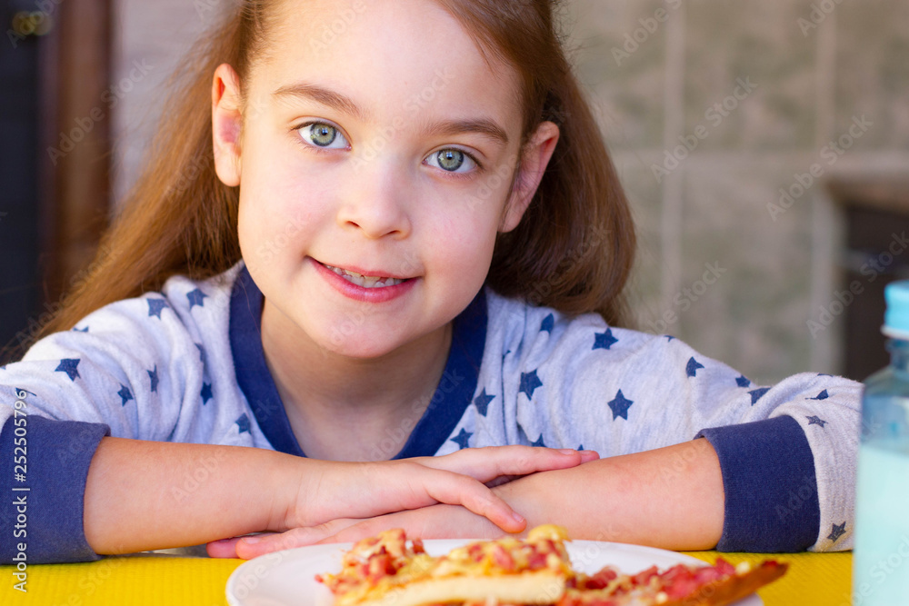  child eating pizza at home.