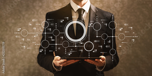 Connected circles chart with businessman holding a tablet computer on a dark vintage background