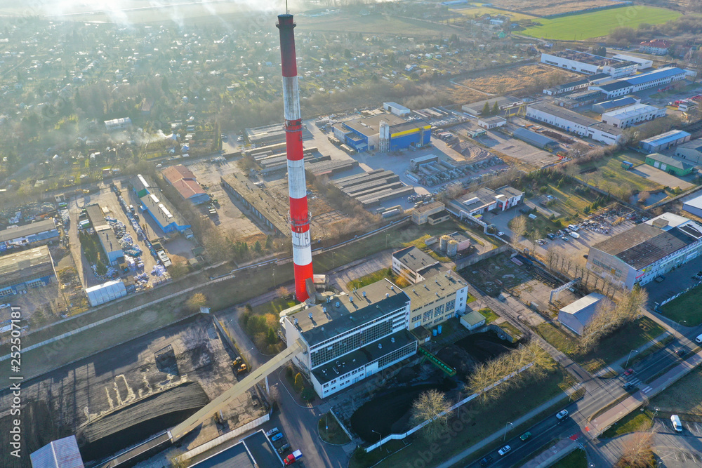 Naklejka premium Heating plant with high chimney in city area, aerial view.
