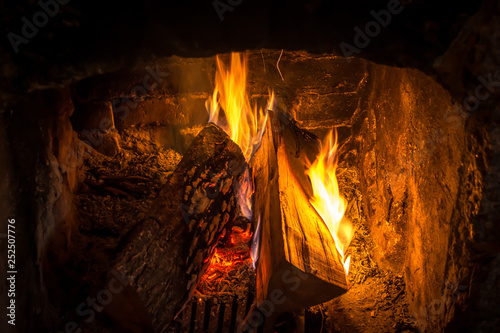 Firewood burning in an old fireplace close up