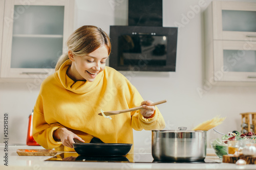 Enthusiastic lady smiling and trying food from the frying pan