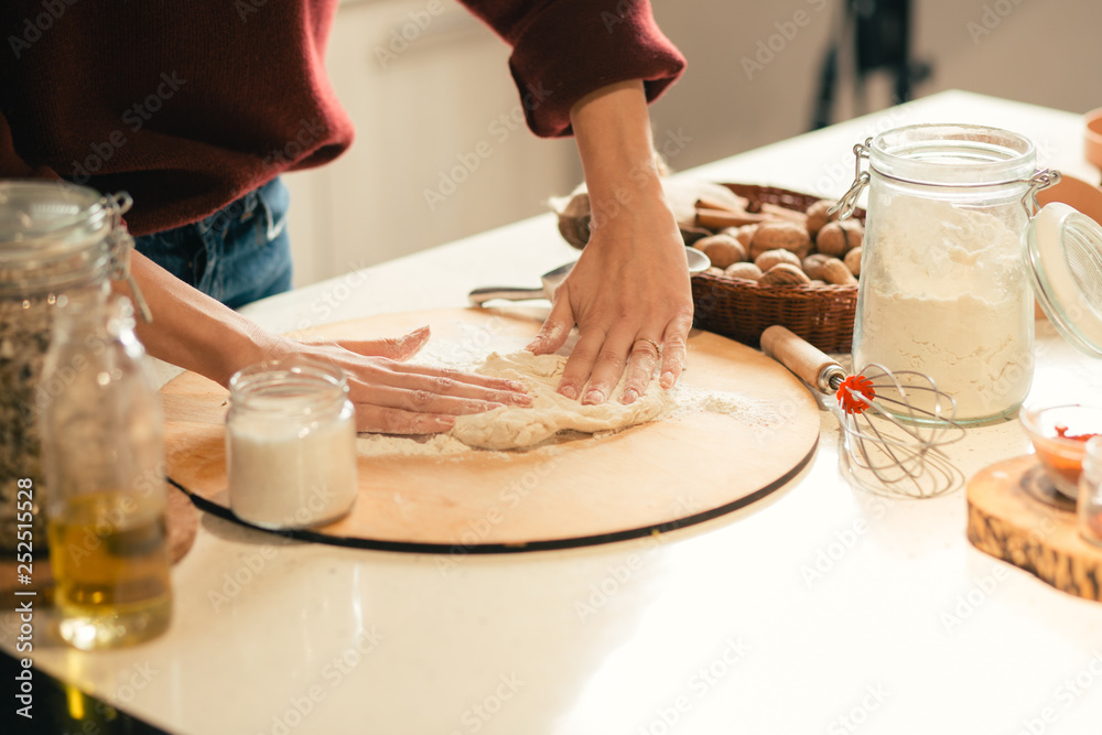 Close up of the dough and woman putting hands on it Close up of the dough and woman putting hands on it