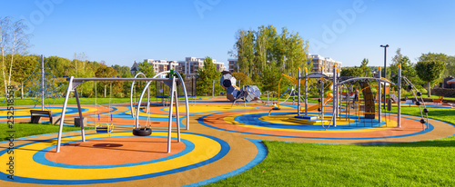 Panorama of colorful large playground in city park. Empty modern outdoor playground in summer. Beautiful urban place for kids games and sport. Scenic view of children ground.
