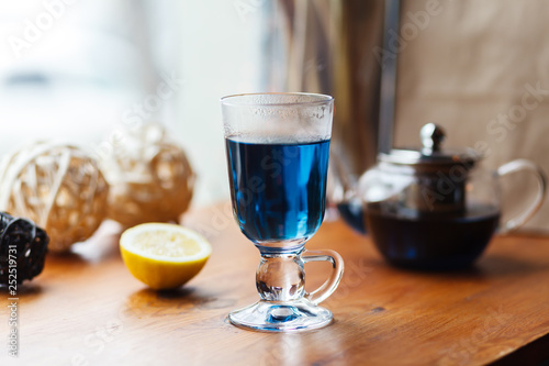 Blue tea Anchan in an Irish glass on a gray background. Cup of Butterfly pea tea, pea flowers, blue pea. Healthy, detox