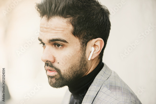 Close up portrait of bearded man with headphone listening voice message.