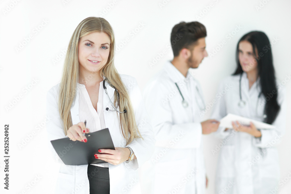 serious therapist with a clipboard while standing in clinic serious therapist with a clipboard while standing in clinic