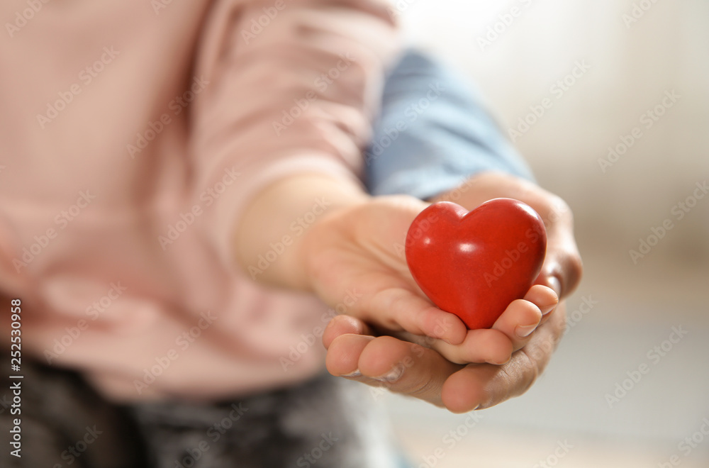 Man and his daughter holding red heart on blurred background, closeup. Children's doctor Man and his daughter holding red heart on blurred background, closeup. Children's doctor