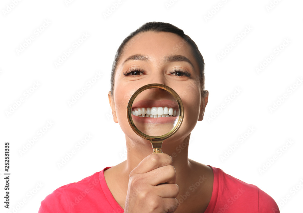 Young woman with healthy teeth and magnifier on white background Young woman with healthy teeth and magnifier on white background