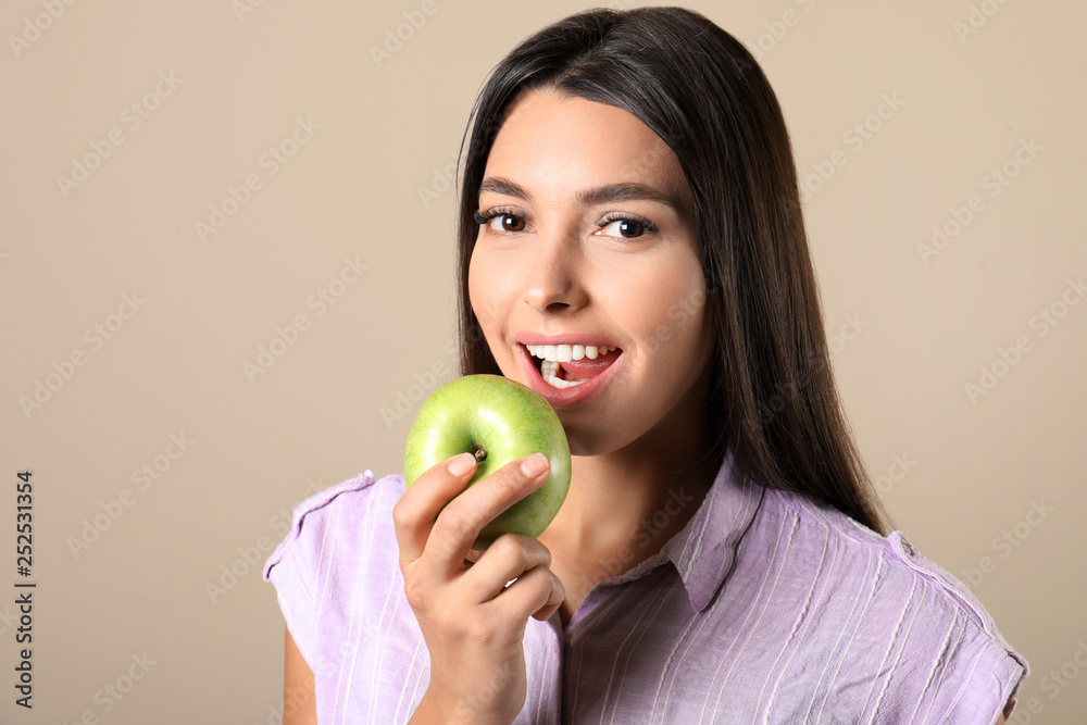 Young woman with healthy teeth and apple on color background Young woman with healthy teeth and apple on color background