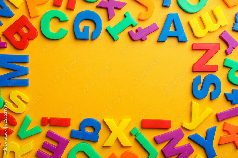 Frame made of plastic magnetic letters on color background, top view with space for text Frame made of plastic magnetic letters on color background, top view with space for text