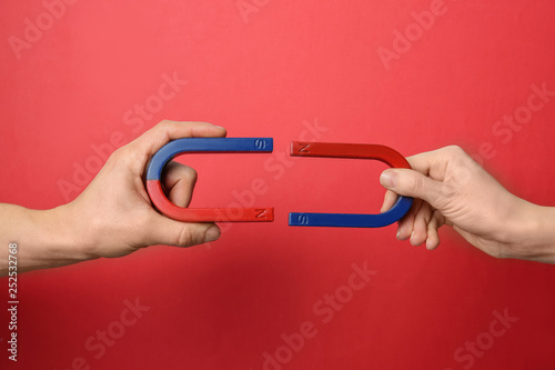 People holding magnets on color background, closeup photo