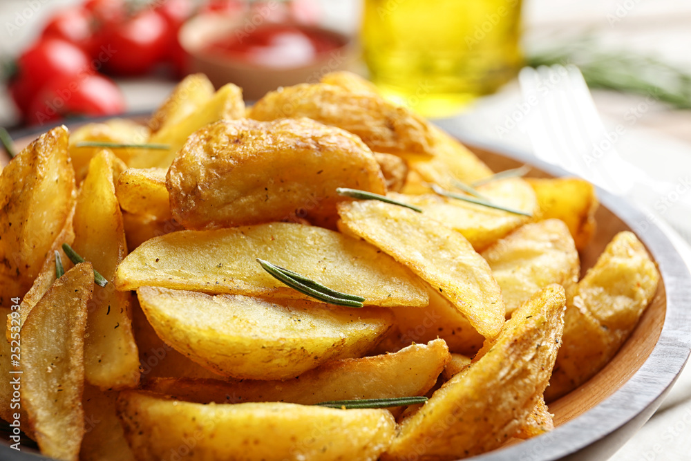 Plate with tasty baked potato wedges on table, closeup Plate with tasty baked potato wedges on table, closeup