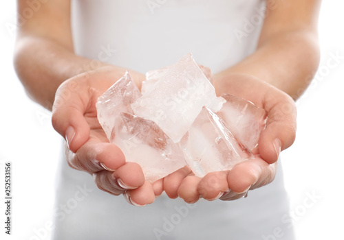 Woman holding many ice cubes on white background, closeup photo