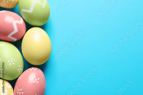 Beautiful painted Easter eggs on color background, flat lay. Space for text