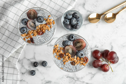 Tasty chia seed pudding with granola served on table, flat lay
