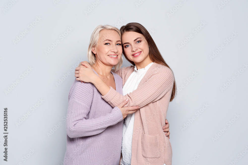 Portrait of mature woman and her daughter on color background Portrait of mature woman and her daughter on color background