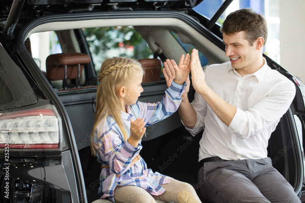 Father and daughter at the car dealership Father and daughter at the car dealership