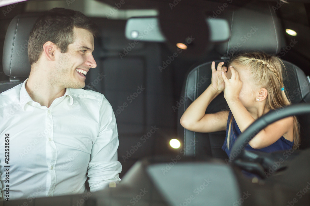 Young man and his daughter in a car - obrazy, fototapety, plakaty 