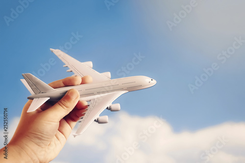 toy plane in hand of kid against blue sky