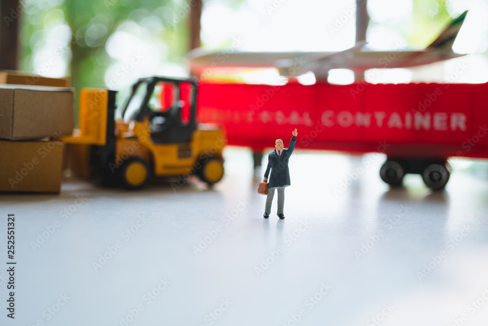 Miniature people, businessman standing on logistic vehicle background using as business and logistics concept