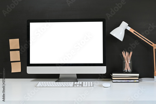 Workspace blank screen desktop computer, Mockup computer, lamp and home office accessories on white desk.