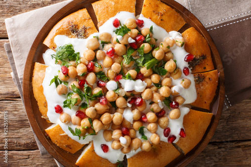 Fatteh Pita with Chickpeas and Yogurt traditional arabic dish closeup on a plate. horizontal top view photo