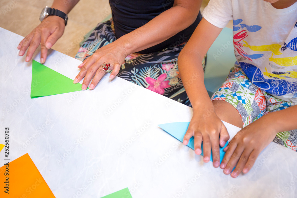 People are learning to fold blue color paper People are learning to fold blue color paper
