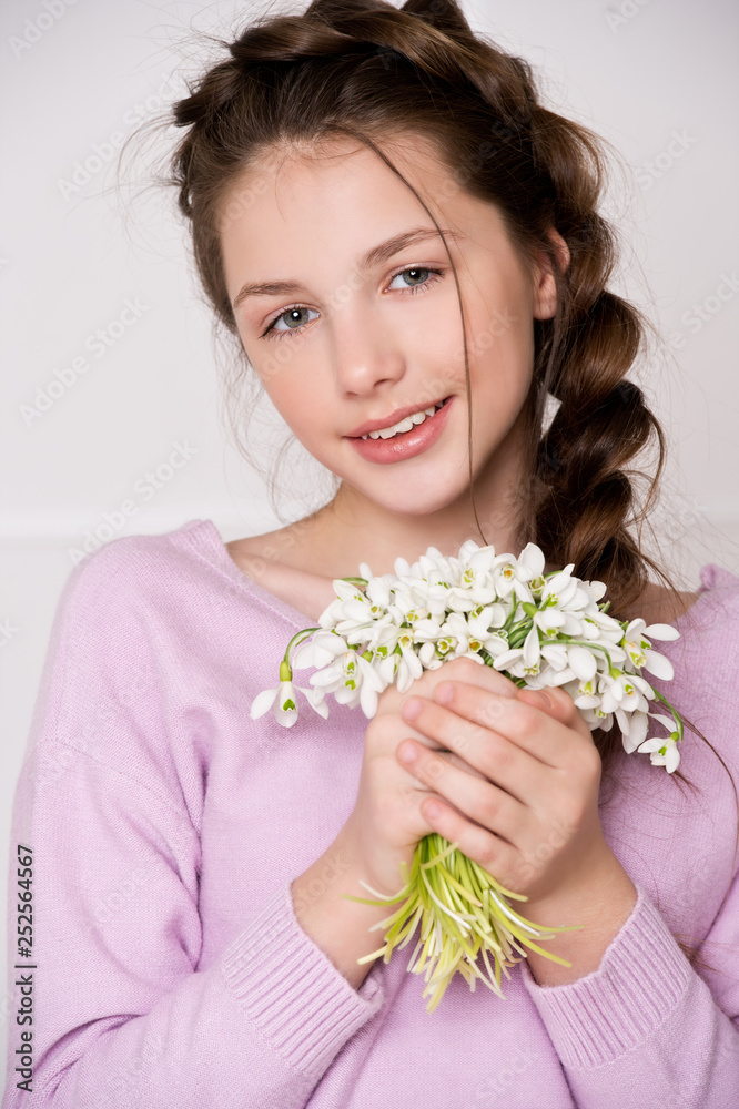 Beautiful girl in denim clothes with flowers snowdrops. Schoolgirl. Beautiful girl in denim clothes with flowers snowdrops. Schoolgirl.