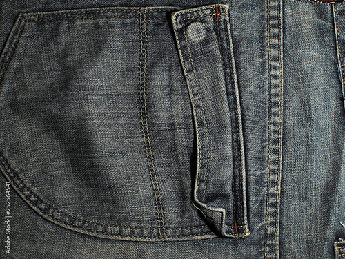 Old faded blue jeans. Macro. Pocket on old blue jeans.