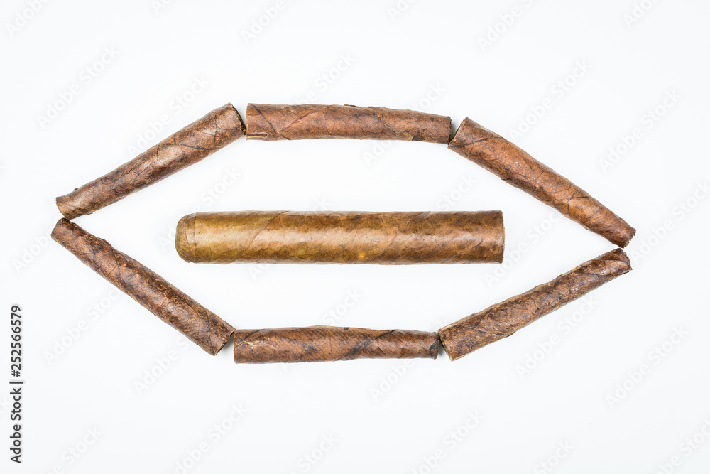Big and small cigars twisted from sheets of tobacco on white background. Big and small cigars twisted from sheets of tobacco on white background.