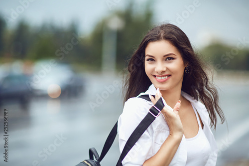 Beautiful happy brunette woman smiling outdoors on city street. 