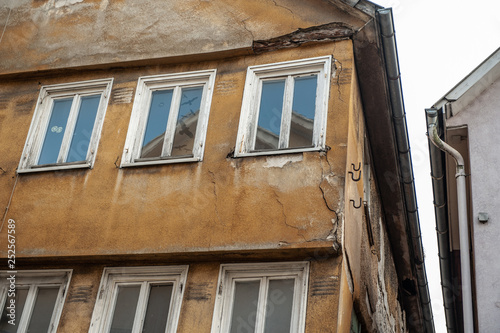 Mittelalter Altbau mit bröckelndem Hausputz und Spiegelungen in den Fenstern