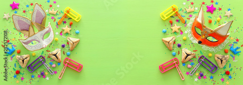 Purim celebration concept (jewish carnival holiday) over wooden green background. top view, flat lay. banner