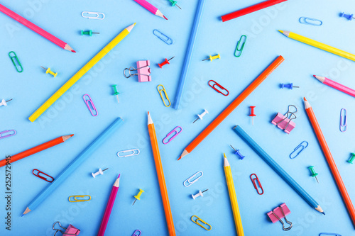 Colored pencils, paper clips and pins, school supplies for drawing, pattern, copy space. © Plutmaverick