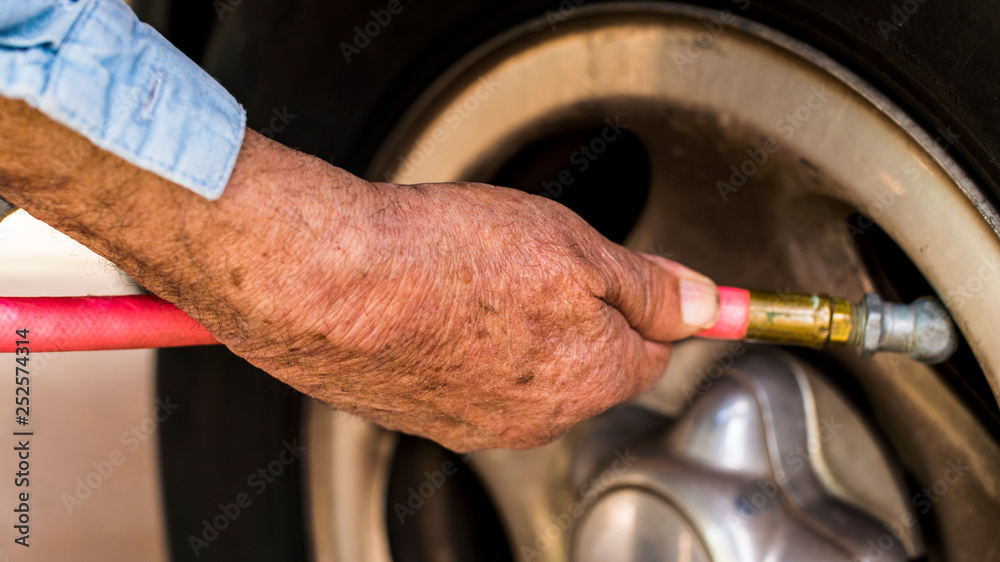 Old Male Hand Air Hose Into Flat Tire