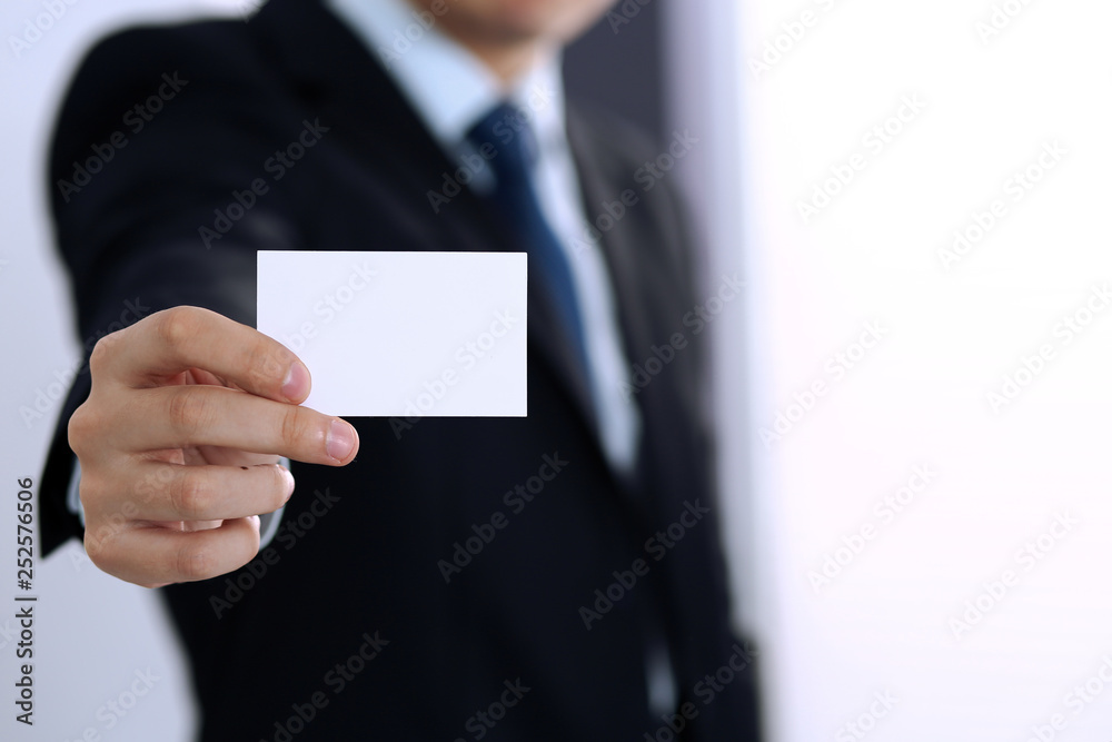 Unknown businessman hand holding business card with empty space, close-up Unknown businessman hand holding business card with empty space, close-up